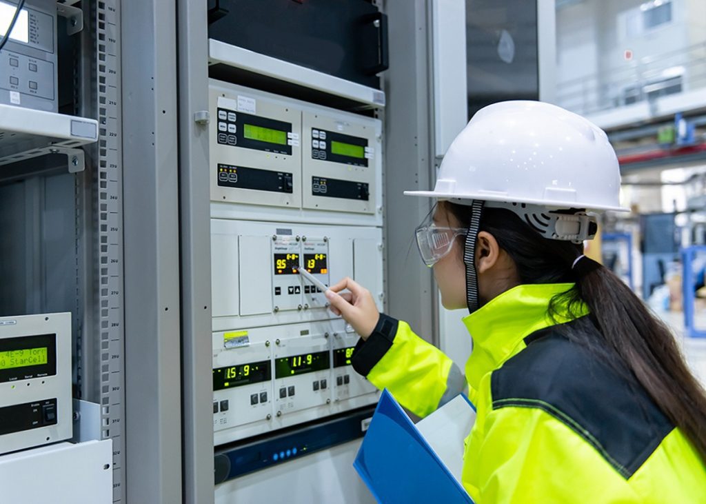 A woman is working on a machine.