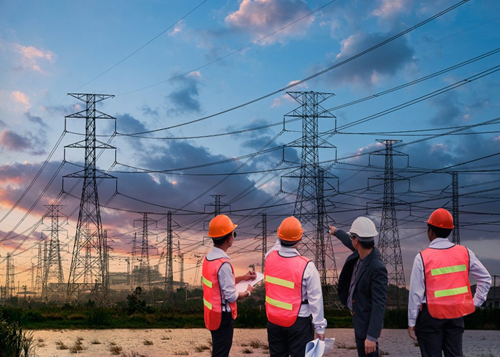 A group of construction workers standing in front of a power line at home.