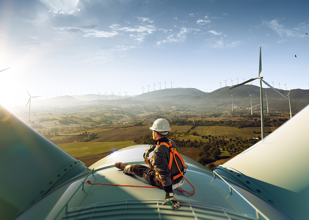 A man accessing support services on top of a wind turbine.